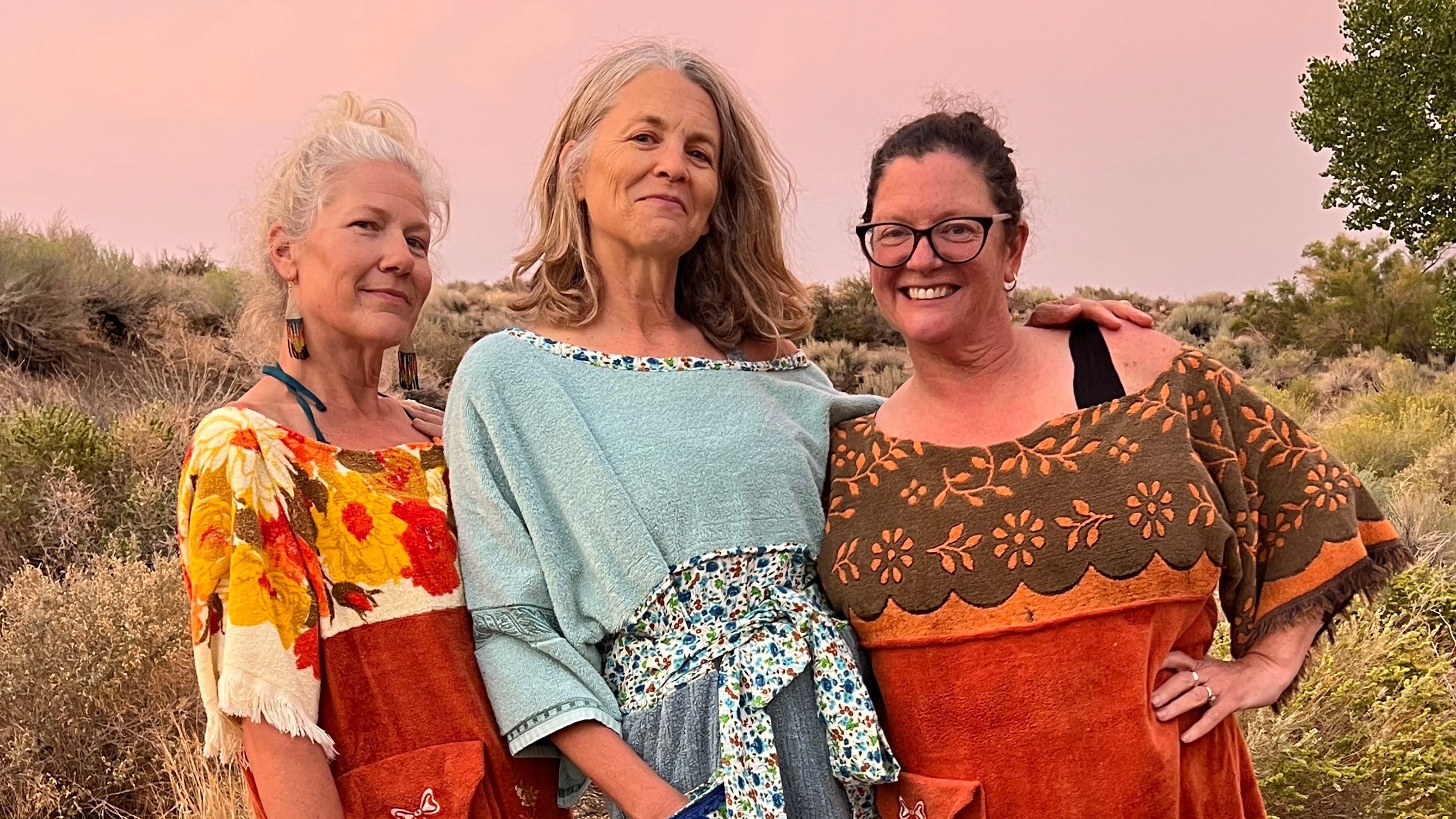 three people standing in a scenic location with handmade towel dresses
